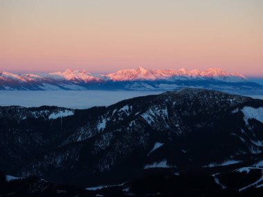 Low Tatras 'ın yüksek Tatraları, kışın gün batımında dağları kapladı