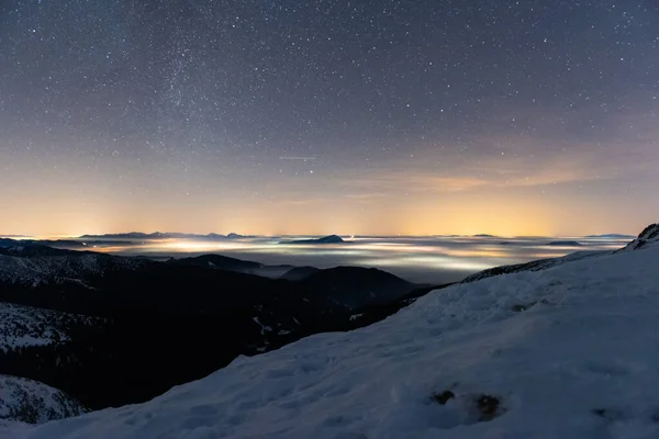 Dağların üzerinde büyülü yıldızlı gece ve kışın sisli vadi, Low Tatras Ulusal Parkı Slovakya