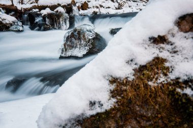 Nehrin donmuş arazide akışı. Donmuş nehirdeki donmuş kayalar.