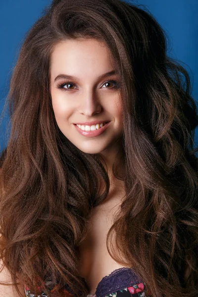 Hermoso maquillaje facial de cerca. Piel sana perfecta.Maquillaje de glamour de moda. .Retrato de mujer joven hermosa y sexy sobre fondo azul.Mujer con cabello castaño largo de belleza posando en el estudio — Foto de Stock