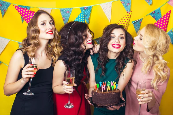 Portret van vrolijke vrienden roosteren en camera op verjaardagsfeestje te kijken. Aantrekkelijke vrienden vieren een verjaardag. Lachende meisjes met glazen champagne — Stockfoto