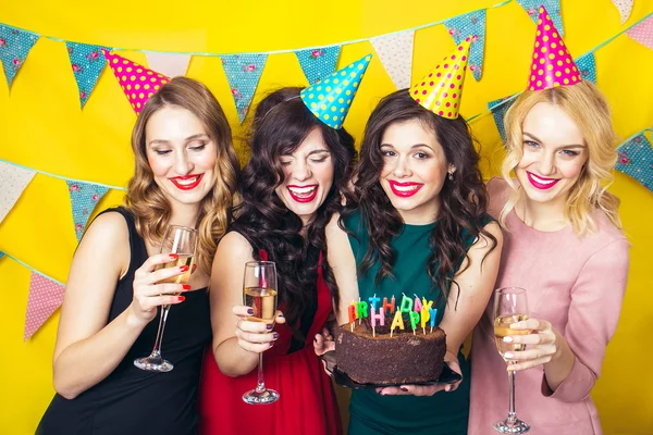 Portret van vrolijke vrienden roosteren en camera op verjaardagsfeestje te kijken. Aantrekkelijke vrienden vieren een verjaardag. Lachende meisjes met glazen champagne — Stockfoto