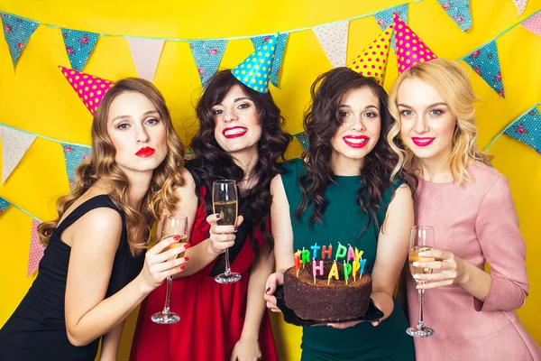 Portret van vrolijke vrienden roosteren en camera op verjaardagsfeestje te kijken. Aantrekkelijke vrienden vieren een verjaardag. Lachende meisjes met glazen champagne — Stockfoto