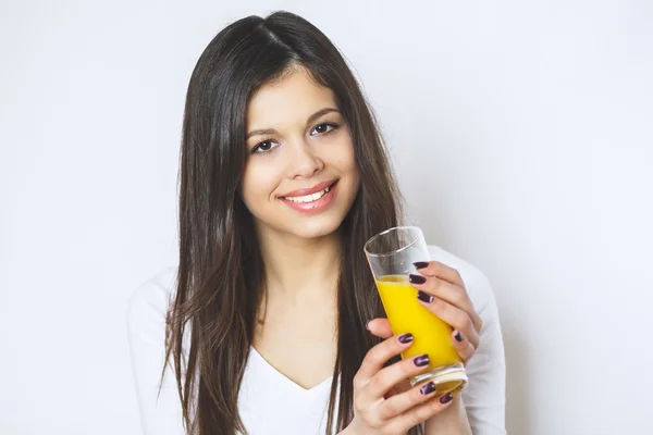 Porträt der attraktiven kaukasischen lächelnden Frau isoliert auf weißen Studioaufnahmen trinkend Orangensaft Gesichtshaut. Porträt einer hübschen Frau im Glas mit leckerem Saft . — Stockfoto