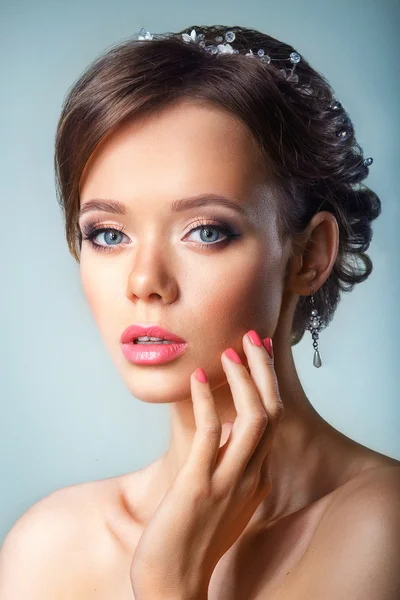 Retrato da menina bonita em uma imagem da noiva com ornamento no cabelo.Mulher de Spa bonita tocando seu rosto. Conceito de cuidados com a pele e juventude . — Fotografia de Stock