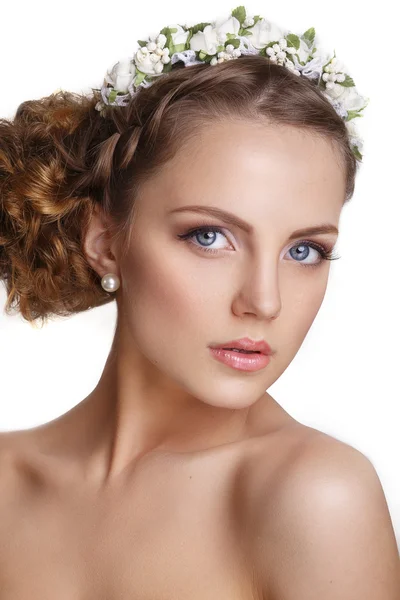 Hermosa joven con un adorno floral en su pelo.Hermosa mujer tocando su cara. Concepto de Cuidado de la Juventud y la Piel sobre fondo blanco — Foto de Stock