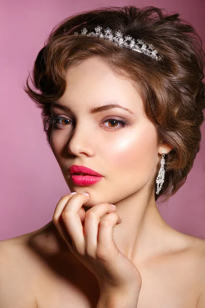 Retrato de novia hermosa. Vestido de novia. Decoración de la boda. Retrato de una hermosa mujer en la imagen de la novia con una joya en el pelo. Foto tomada en el estudio sobre fondo rosa . —  Fotos de Stock