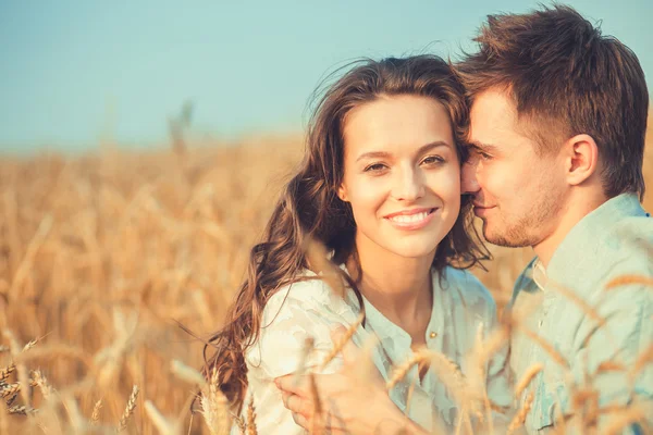 Young couple in love outdoor.Stunning sensual outdoor portrait of young stylish fashion couple posing in summer in field.Happy Smiling Couple in love.They are smiling and looking at each other — Zdjęcie stockowe