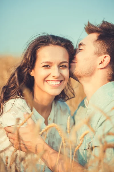 Young couple in love outdoor.Stunning sensual outdoor portrait of young stylish fashion couple posing in summer in field.Happy Smiling Couple in love.They are smiling and looking at each other — Stok fotoğraf