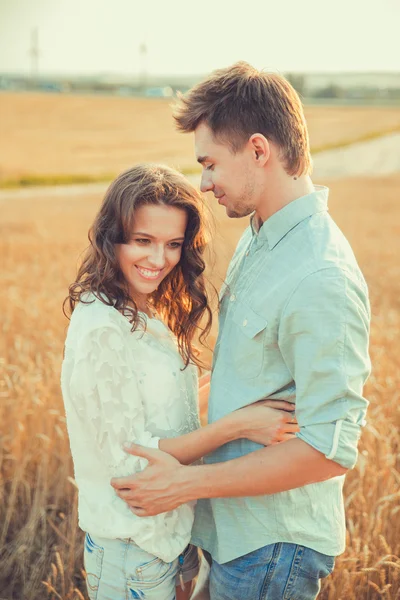 Young couple in love outdoor.Stunning sensual outdoor portrait of young stylish fashion couple posing in summer in field.Happy Smiling Couple in love.They are smiling and looking at each other — Φωτογραφία Αρχείου