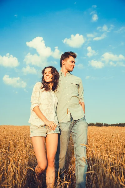 Young couple in love outdoor.Stunning sensual outdoor portrait of young stylish fashion couple posing in summer in field.Happy Smiling Couple in love.They are smiling and looking at each other — Φωτογραφία Αρχείου