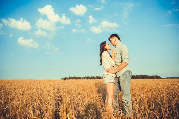 Young couple in love outdoor.Stunning sensual outdoor portrait of young stylish fashion couple posing in summer in field.Happy Smiling Couple in love.They are smiling and looking at each other — Stock Fotó