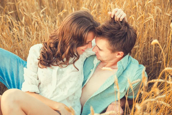 Young couple in love outdoor.Stunning sensual outdoor portrait of young stylish fashion couple posing in summer in field.Happy Smiling Couple in love.They are smiling and looking at each other Stock Photo