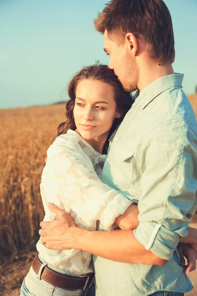 Ungt par i kärlek utomhus. Fantastiska sensuella utomhus porträtt av unga snygga mode par poserar på sommaren i fältet — Stockfoto