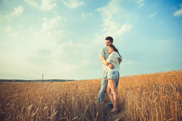 Young couple in love outdoor. Stunning sensual outdoor portrait of young stylish fashion couple posing in summer in field. Happy Smiling Couple in love. They are smiling and looking at each other — Stock Photo, Image