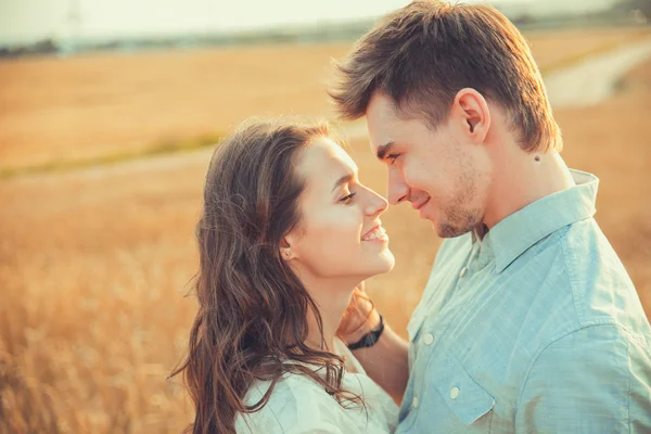 Genç çift aşık açık. Yaz aylarında alanında poz genç şık moda çift şehvetli açık portresi çarpıcı. Gülümseyen mutlu çift aşık. Gülümseyen ve birbirine bakarak