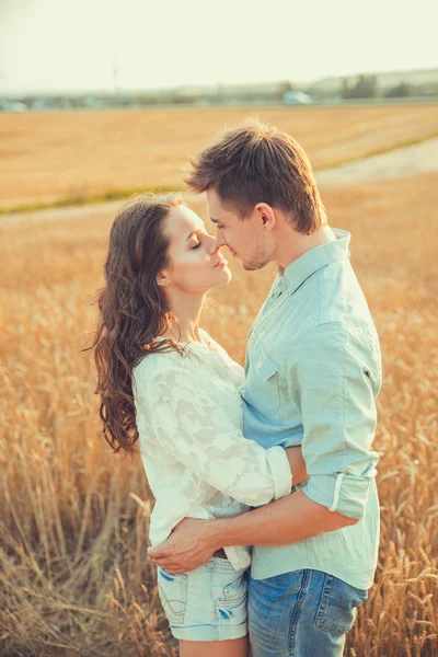 Jong koppel in liefde buiten. Schitterende sensuele outdoor portret van de jonge stijlvolle mode paar poseren in de zomer in veld. Gelukkige paar, glimlachen, in de liefde. Ze glimlachen en kijken naar elkaar — Stockfoto