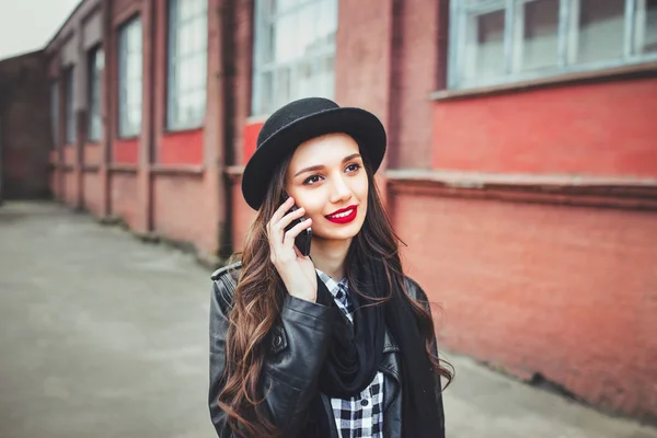 Young pretty girl in hat using smartphone.Woman using smartphone to make a call  in the street — Φωτογραφία Αρχείου