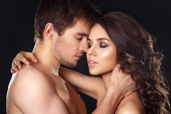 Sexy pareja de belleza.Besos pareja retrato.Sensual morena mujer en ropa interior con joven amante, apasionada pareja juego previo primer plano — Foto de Stock