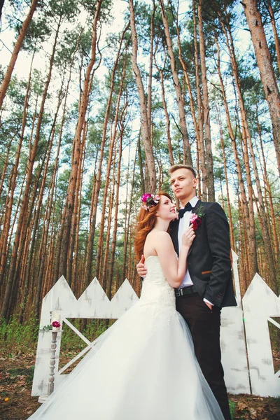 Hochzeitsfoto von Braut und Bräutigam im Park. Hochzeitspaar gerade mit Brautstrauß verheiratet. stilvoll glücklich lächelndes Brautpaar bei der Trauung im Freien — Stockfoto