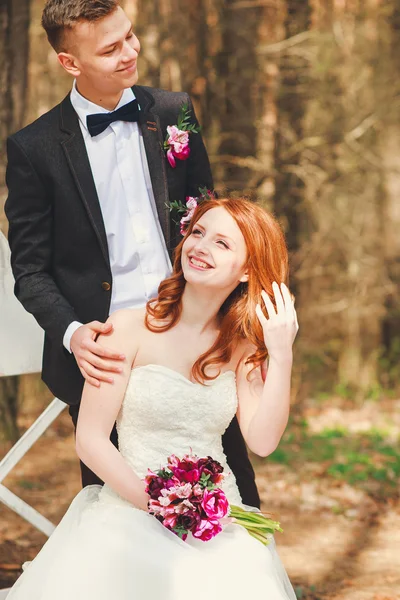 Bröllop skott av bruden och brudgummen i park. Brudparet gifta sig bara med brudbukett. Snygga glada leende nygifta på utomhus bröllop — Stockfoto