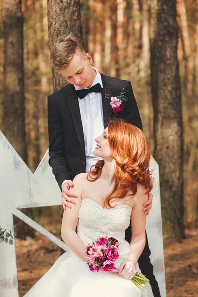 Plan de mariage de mariée et marié dans le parc. Couple de mariage vient de se marier avec bouquet nuptial. Élégant heureux souriant jeunes mariés sur la cérémonie de mariage en plein air — Photo