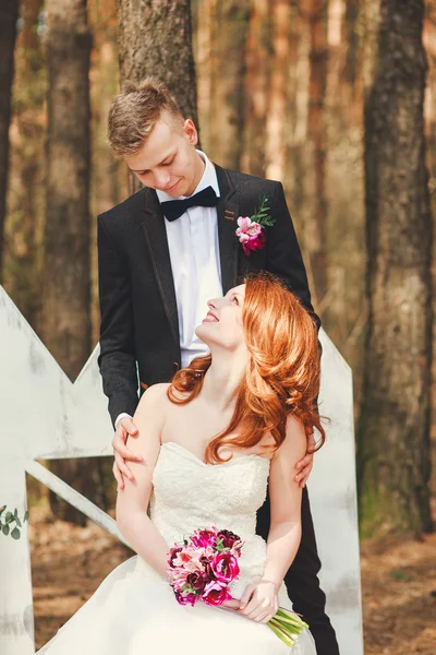 Tiro de casamento de noiva e noivo no parque. Casamento casal acaba de se casar com buquê de noiva. Elegante feliz sorrir recém-casados na cerimônia de casamento ao ar livre — Fotografia de Stock