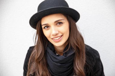 Yüzünde gülümseme ile kentsel kız gülümsüyor. Moda kız açık havada şehirde eğleniyor bir rock siyah stil giyen portresi