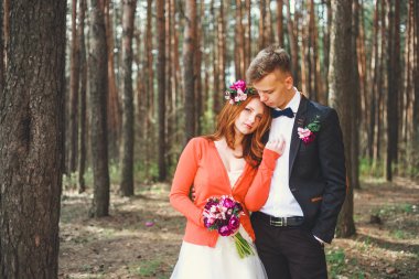 Parkta gelin ve damadın düğün fotoğrafı. Düğün çifti gelinlik buketi ile evlendi. Açık düğün töreninde şık mutlu gülümseyen yeni evliler. Aşık açık genç çift.