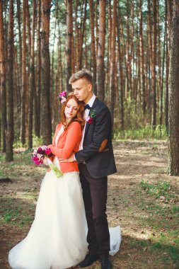 Parkta gelin ve damadın düğün fotoğrafı. Düğün çifti gelinlik buketi ile evlendi. Açık düğün töreninde şık mutlu gülümseyen yeni evliler. Aşık açık genç çift.