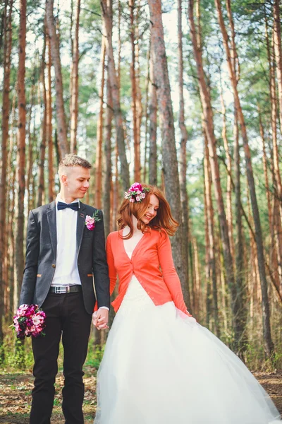 Bruiloft shot van de bruid en bruidegom in park. Bruidspaar net getrouwd met bruids boeket. Jong koppel in liefde buiten. — Stockfoto