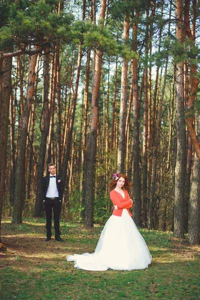 Hochzeitsfoto von Braut und Bräutigam im Park. Hochzeitspaar gerade mit Brautstrauß verheiratet. stilvoll glücklich lächelnde Frischvermählte bei einer Trauung im Freien. junges verliebtes Paar im Freien. — Stockfoto