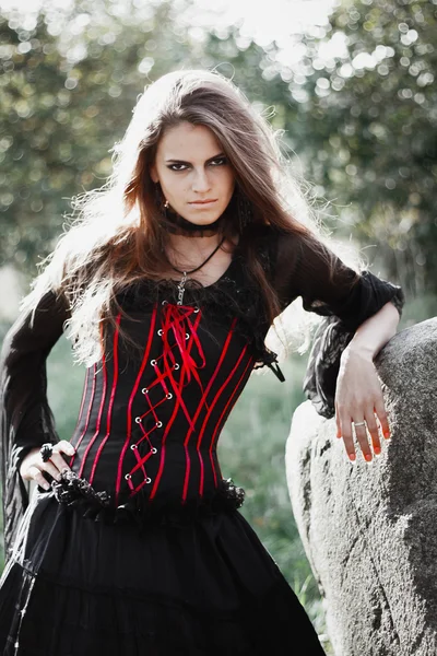 Sorcière d'Halloween dans une forêt sombre. Belle jeune femme en costume de sorcières. Horreur arrière-plan pour Halloween Concept — Photo