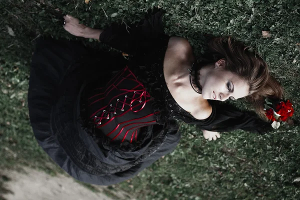 Halloween czarownica w ciemnym lesie. Piękna młoda kobieta w stroju wiedźmy. Tło horror Halloween Concept — Zdjęcie stockowe