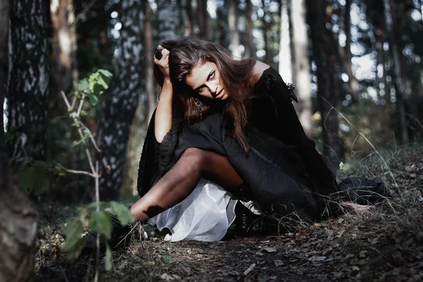 Sorcière d'Halloween dans une forêt sombre. Belle jeune femme en costume de sorcières. Horreur arrière-plan pour Halloween Concept — Photo
