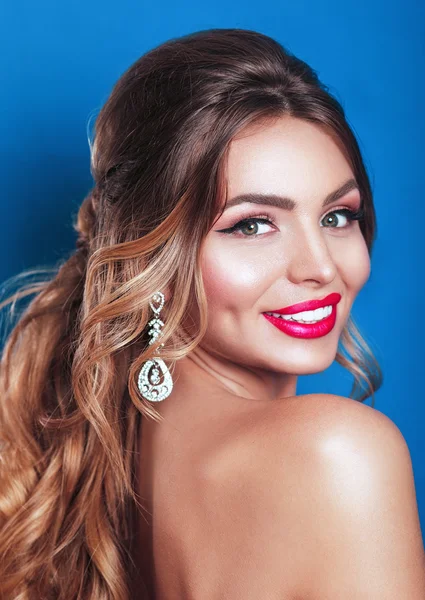 Beauty model woman with beautiful make up and curly hair style over holiday dark background with magic glow. Holiday celebration. Brunette Glamour lady with perfect make up and hairstyle .