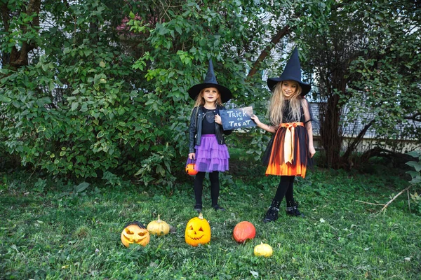 Halloween små flickor i häxa dräkt ut för bus-eller-godis — Stockfoto