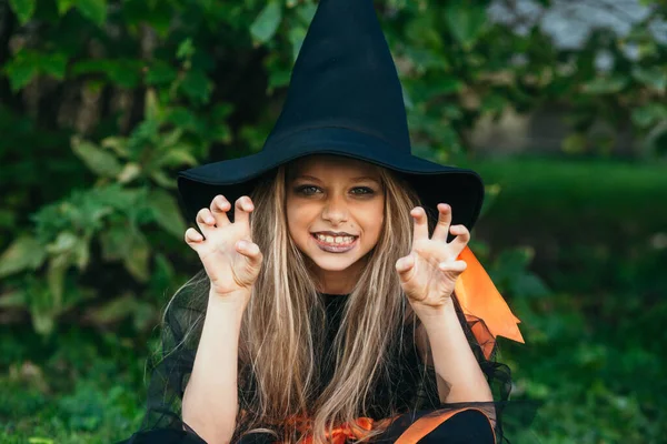 Niña con disfraz de bruja divirtiéndose en truco o trato de Halloween — Foto de Stock