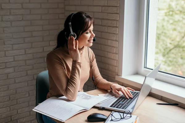 Gericht jonge vrouw dragen hoofdtelefoon studie online thuis — Stockfoto