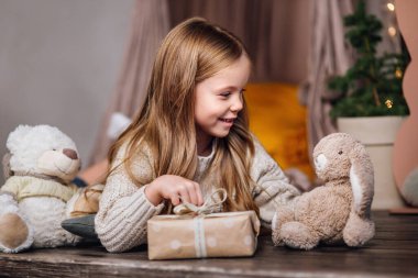 Sevimli küçük çocuk evde oyuncaklarla oynuyor.