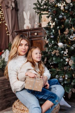 Mutlu aile hediyelerini Noel sabahı ağacın yanında açar.