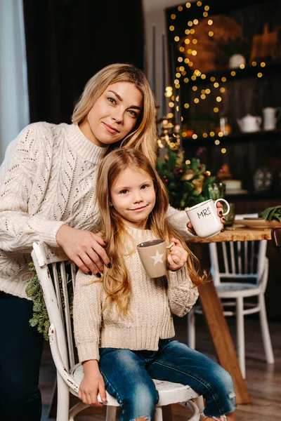 행복 한 어린 소녀와 어머니가 집에서 우유와 함께 과자를 먹는 모습 — 스톡 사진