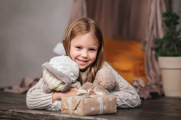 Маленькая девочка лежит среди рождественских подарков дома . — стоковое фото
