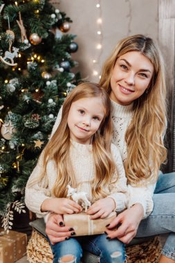 Mutlu aile hediyelerini Noel sabahı ağacın yanında açar.