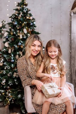 Mutlu aile hediyelerini Noel sabahı ağacın yanında açar.