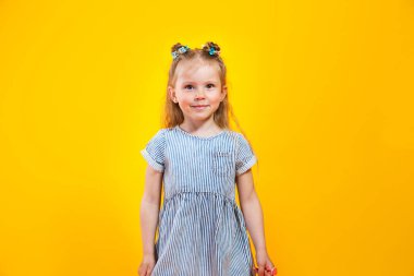 Happy caucasian child girl smiling to camera over yellow background