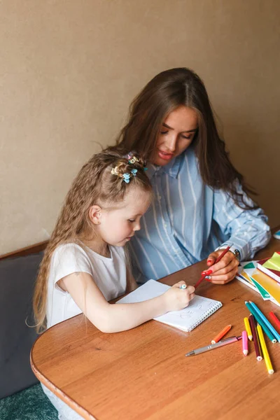 Anya segít a gyerekének házi feladatot csinálni otthon. — Stock Fotó