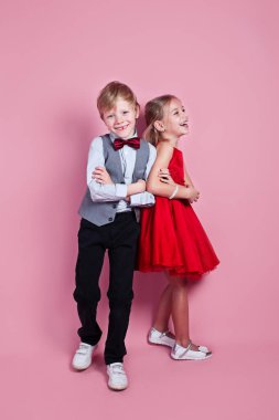 Sevgililer Günü konsepti pembe bir arka planda duran sevimli, gülümseyen kız ve erkek. .