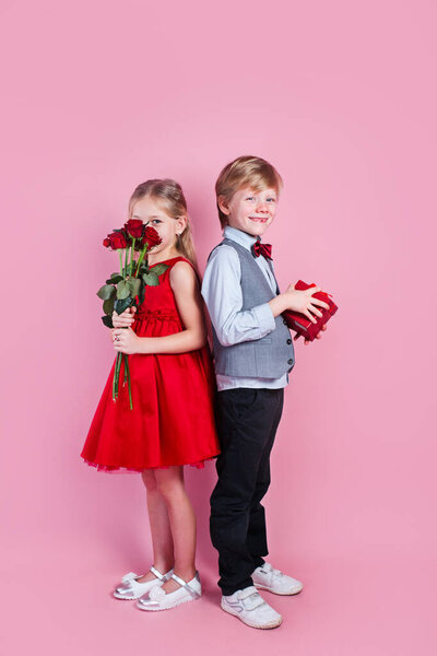 Valentines day surprise. Little boy in love giving cute girl red rose ,