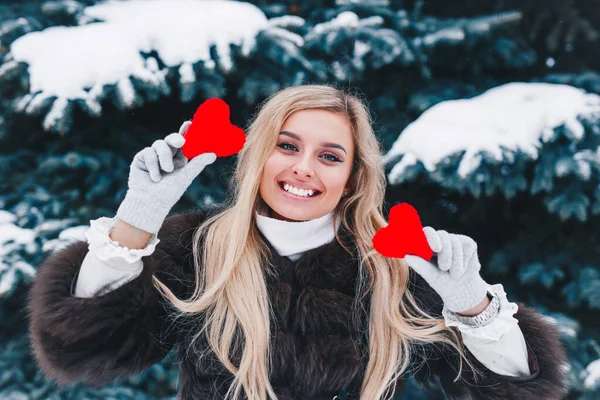 День Святого Валентина. Красивая улыбающаяся женщина с красными сердцами в руках в лесу . — стоковое фото